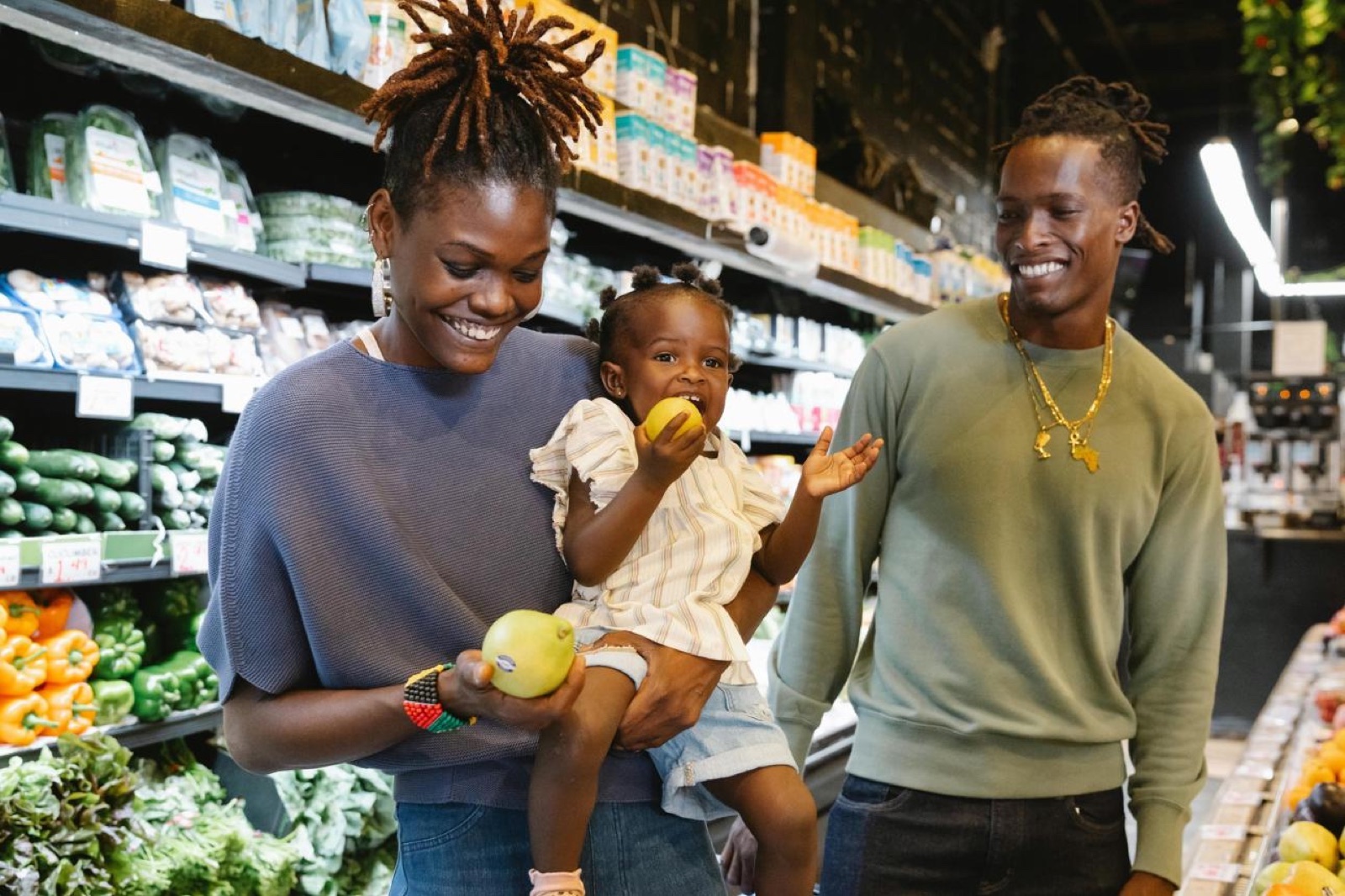 Une famille fait ses courses au rayon fruits et légumes