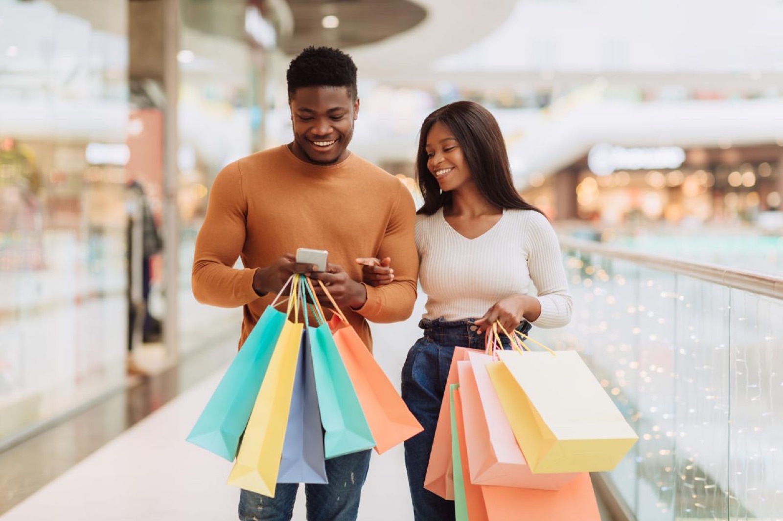 Deux clients sortent d’un centre commercial avec leurs achats