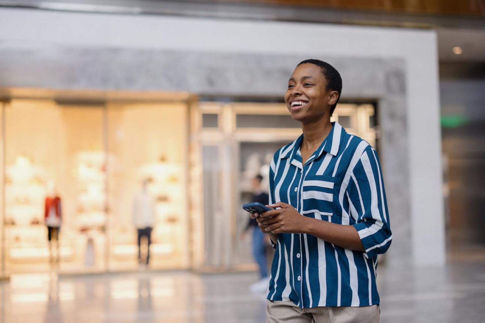 Une cliente consulte son téléphone dans une galerie commerçante